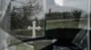 FILE - A cross is reflected on a broken window of a village church in Ukraine's southern Kherson region, amid Russia's invasion of its neighbor, Dec. 30, 2022.