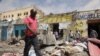 Sejumlah warga mengamati tempat lokasi serangan yang dilancarkan oleh kelompok militan al Shabaab, yang terkait dengan Al Qaeda, di Mogadishu, Somalia, pada 21 Agustus 2022. (Foto: Reuters/Feisal Omar)