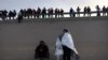 Migrantes son cargados en una camioneta mientras son procesados por la Patrulla Fronteriza después de cruzar ilegalmente el río Bravo desde México hacia EEUU en Texas, el 26 de agosto de 2022.