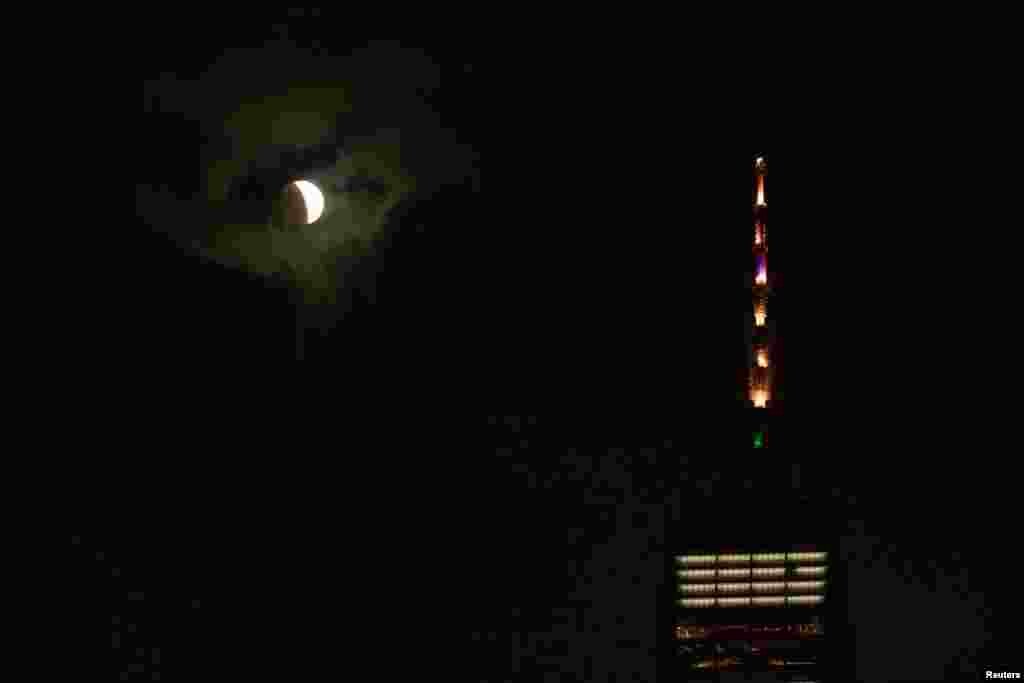 Una luna llena se mueve a través de la sombra de la Tierra durante un eclipse lunar de "luna de sangre" cerca del One World Trade Center.