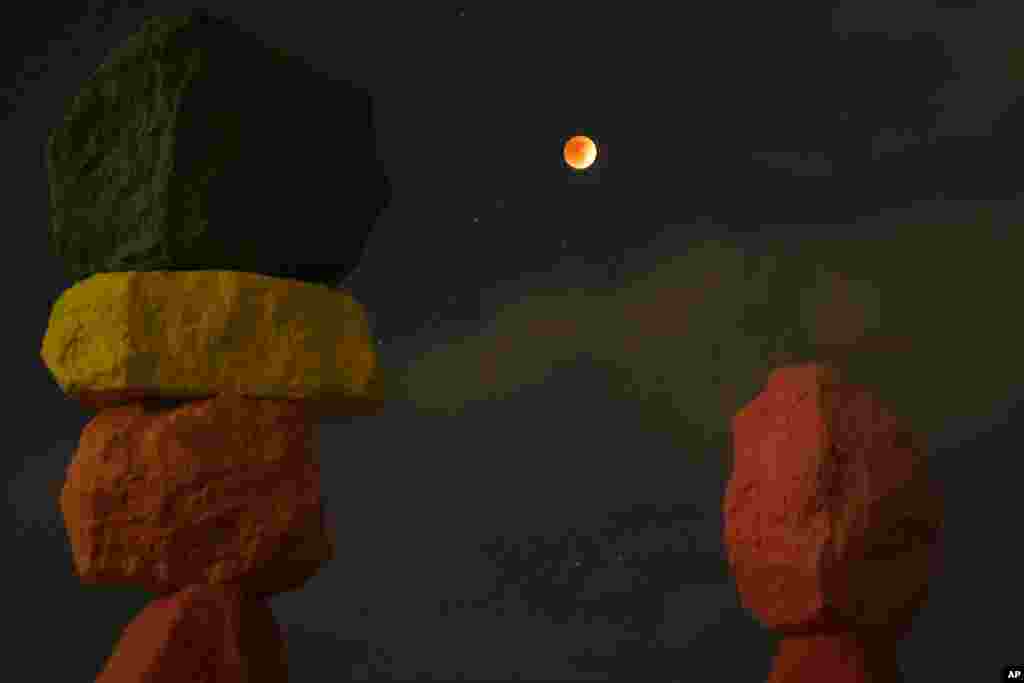 El eclipse lunar sobre la obra de arte titulada 'Siete montañas mágicas', del artista Ugo Rondinone, durante la primera luna de sangre del año, cerca de Jean, Nevada..