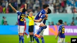 Japan players celebrate at the end of the World Cup group E soccer match between Japan and Spain, at the Khalifa International Stadium in Doha, Qatar, Dec. 1, 2022. Japan won 2-1.