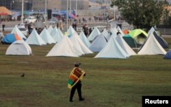 Seorang demonstran berjalan menuju tenda-tenda di dalam area protes, yang dijuluki desa Gota-Go, di mana orang-orang berkumpul menentang Presiden Sri Lanka Gotabaya Rajapaksa di dekat Sekretariat Presiden di Kolombo, Sri Lanka, di tengah krisis ekonomi negara itu, 12 April, 2022. (REUTERS/Dinuka Liyanawatte)