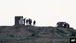 Fighters of People's Protection Units, or YPG, gather at their outpost west of the city of Kobani, northern Syria, Dec. 18, 2018.