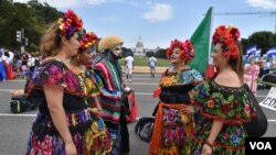 Integrantes de una compañía de danza folclórica mexicana conversan antes de salir de la Explanada Nacional en Washington DC. Al fondo el emblemático Capitolio en la capital estadounidense. (Foto VOA / Tomás Guevara)