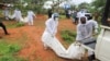Forensic experts and homicide detectives carry the bodies of suspected members of a Christian cult named Good News International Church after their remains were exhumed from their graves in Shakahola forest of Kilifi county, Kenya, April 22, 2023.
