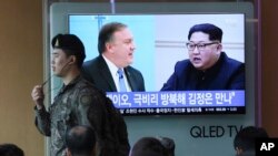 一名韩国军人在首尔火车站走过正在播放蓬佩奥会见金正恩的电视画面。（2018年4月18日）