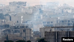 Smoke rises from central Kobani during fighting between Islamic State militants and Kurdish forces, as seen from the Turkish side of the Turkey-Syria border, Nov. 24, 2014. 