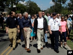 El presidente Donald Trump visita un vecindario afectado por el huracán Florence el miércoles 19 de septiembre de 2018 en Conway, Carolina del Sur. A la izquierda está el administrador de FEMA Brock Long y el gobernador de Carolina del Sur Henry McMaster, segundo desde la izquierda. (AP Photo / Evan Vucci)