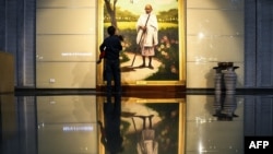 Seorang anak sedang memperhatikan lukisan ikon perjuangan kemerdekaan India, Mahatma Gandhi, yang dipamerkan di Museum President's House di New Delhi, India, 28 Juli 2018.