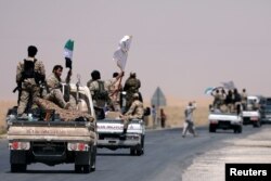 FILE - Syrian Democratic Forces fighters head to Raqqa, Syria, June 6, 2017.