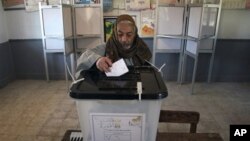 Seorang pria Mesir memasukkan surat suaranya untuk putaran kedua referendum konstitusi di sebuah TPS di Fayoum, sekitar 100 kilometersebelah selatan Kairo, Mesir, Sabtu (22/12). 
