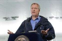 FILE - New York City Mayor Bill de Blasio speaks at the USTA Indoor Training Center, used as a 350-bed temporary hospital, in New York, March 31, 2020.