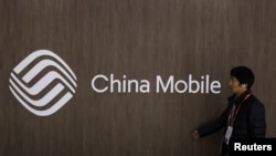 西班牙巴塞羅那一個行人路過中國移動徽標