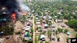 FILE - A fire burns in the predominantly ethnic Rakhine village of Let Kar in Rakhine State's Mrauk-U township, western Myanmar, May 16, 2020.