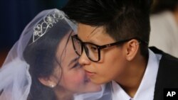 Filipino LGBT (Lesbians Gays Bisexual and Transgenders) couple Allen Grace Bagares, right, and Karen Kaye Sarmiento chat during a "Rite of Holy Union" ceremony in suburban Quezon city, Manila, Philippines, June 28, 2015. 