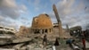 Orang-orang berdiri di luar masjid yang hancur akibat serangan udara Israel di Khan Younis, Jalur Gaza, Minggu, 8 Oktober 2023. (Foto: AP)