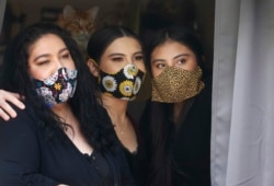 Anissa Archuleta, center, sits at a window with her sister Alexis Archuleta, right, and her mother Jaime Ortega, at their home in Midvale, Utah, May 18, 2020.