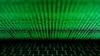 FILE - This photo illustration shows a computer keyboard lit by displayed cyber code.