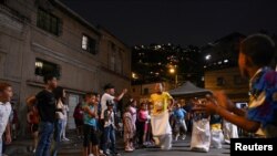 Niños juegan en el barrio de San Agustín durante la tradicional quema de Judas, como parte de las celebraciones de Semana Santa en Caracas, Venezuela, 9 de abril de 2023. REUTERS/Gaby Oraa