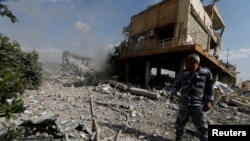 FILE - A Syrian firefighter is seen inside the destroyed Scientific Research Center in Damascus, Syria, April 14, 2018.