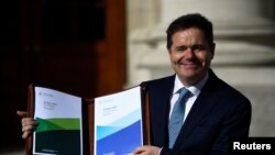 Menteri Keuangan Irlandia Paschal Donohoe memperlihatkan salinan anggaran 2019 di Government Buildings di Dublin, Irlandia, 9 Oktober 2018.
