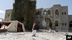 FILE - A man loyal to former Yemeni president Ali Abdullah Saleh stands guard at Saleh's house destroyed by a Saudi-led airstrike in Sanaa, Yemen, Sunday, May 10, 2015.