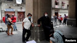 A un hombre le lustran los zapatos cerca de la plaza Zócalo, en la Ciudad de México. 31 de julio de 2020.