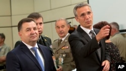 Le secrétaire général de l'Otan, Jens Stoltenberg, à droite, et le ministre de la Défense ukrainien Stepan Poltorak, à gauche, s’apprêtent à participer à une réunion du Conseil Otan-Ukraine au siège de l'Otan à Bruxelles, le 25 juin 2015.