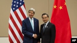 Menteri Luar Negeri AS John Kerry, kiri, bersalaman dengan Menteri Luar Negeri China Wang Yi sebelum memulai rapat di KTT Menteri Luar Negeri ASEAN ke-47 di Naypyitaw, Myanmar, 9 Agustus 2014.