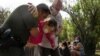 Anggota patroli perbatasan AS membantu seorang migran lansia pencari suaka dari Venezuela setelah sang lansia menyeberang sungai Rio Grande dari Del Rio, Meksiko, menuju Texas, AS, pada 26 Mei 2021. (Foto: Reuters/Go Nakamura)