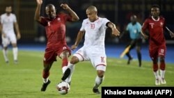 Le milieu de terrain malgache Ibrahim Amada (à gauche) et l'attaquant tunisien Wahbi Khazri lors du match de quart de finale de la Coupe d'Afrique des Nations au Caire le 11 juillet 2019.