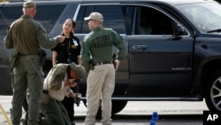 Law enforcement officials process a scene involved in Saturday's shooting, Sunday, Sept. 1, 2019, in Odessa, Texas. 