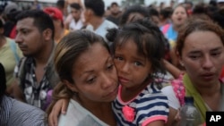 Para migran menuju perbatasan AS-Meksiko menunggu di sebuah jembatan yang membentang di atas Sungai Suchiate, yang menghubungkan Guatemala dan Meksiko, di Tecun Uman, Guatemala, Jumat, 19 Oktober 2018. (Foto: AP)