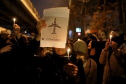 People gather for a candlelight vigil to honor the victims of the Ukraine plane crash, at the gate of Amrikabir University, where some of the victims were former students, in Tehran, Iran, Jan. 11, 2020.