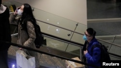 Para penumpang penerbangan langsung dari China mengenakan masker di Bandra International Seattle-Tacoma, di SeaTac, Washington, 23 Januari 2020.