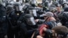 ​Oficiales de policía del Capitolio con equipo antidisturbios hacen retroceder a los manifestantes que intentan romper una puerta del Capitolio de los Estados Unidos el miércoles 6 de enero de 2021 en Washington.