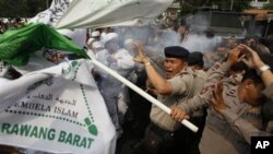 Polisi melemparkan gas air mata untuk membubarkan demonstran yang memrotes film 'Innocence of Muslims' di depan Kedutaan Besar AS di Jakarta, Senin (17/9). (AP/Dita Alangkara)