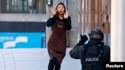 지난 15일 호주 시드니의 한 카페에서 인질극이 벌어진 가운데, 탈출한 인질 한 명이 경찰 쪽으로 향하고 있다.