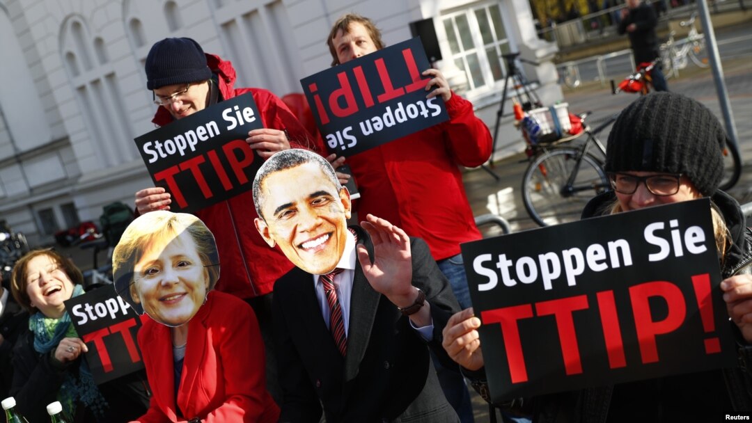 Người biểu tình đeo mặt nạ ông Obama và bà Merkel phản đối thỏa thuận thương mại tự do T-TIP tại hội chợ Hannover Messe ở thành phố Hannover, Đức, ngày 24 tháng 4, 2016.