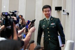 China's Defense Ministry spokesman Wu Qian leaves as journalists are asking question on Hong Kong's recent protests after a press conference at the State Council Information Office in Beijing, July 24, 2019.