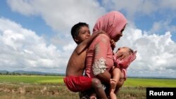Pengungsi Rohingya berjalan di sawah setelah menyeberangi perbatasan di Palang Khali, Bangladesh, 9 Oktober 2017, (REUTERS/Jorge Silva)