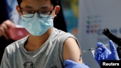 Brendan Lo (13) disuntik vaksin COVID-19 Pfizer-BioNTech di RS Anak-anak Northwell Health's Cohen, New Hyde Park, New York, 13 Mei 2021. (REUTERS/Shannon Stapleton)