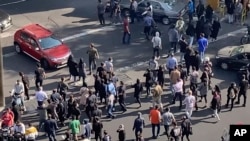 社交媒体上的视频显示伊朗德黑兰的抗议人群堵住了一个交通路口。(2022年10月26日)
