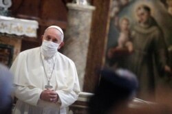 FILE - Pope Francis wears a face mask as he attends an inter-religious prayer service for peace in the Basilica of Santa Maria in Aracoeli, a church on top of Rome's Capitoline Hill, in Rome, October 20, 2020.