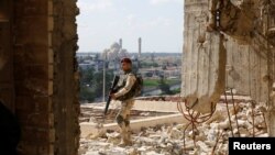 Un guardia de seguridad iraquí custodia el 19 de abril de 2019 un sitio donde actúa el violinista Ameen Mukdad, que permaneció por dos años en donde dominó ISIS en Mosul.