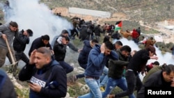 Palestinian demonstrators run for cover during clashes with Israeli troops at a protest against Jewish settlements in the village of Beita, near Nablus in the occupied West Bank February 15, 2018.