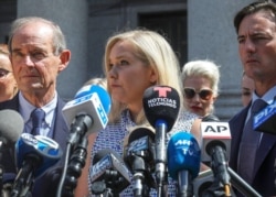 Virginia Giuffre, au centre, qui affirme avoir été victime de la traite des êtres humains par le délinquant sexuel Jeffrey Epstein, lors d'une conférence de presse devant un tribunal de Manhattan, à New York, le 27 août 2019.