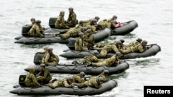 Japan Self-Defense Force (JSDF) soldiers ride rubber boats on the sea approach to Eniyabanare Island during a military drills, off Setouchi town on the southern Japanese island of Amami Oshima, Kagoshima prefecture, in this photo taken by Kyodo May 22, 20
