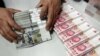 A clerk counts Chinese yuan and U.S. dollar banknotes at a branch of Bank of China in Taiyuan, China, Jan. 4, 2016. China's currency has been slipping in value since Donald Trump became president-elect. 